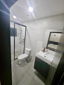 ein Badezimmer mit Toilette, Waschbecken und Spiegel in der Unterkunft DELYA Maria in Abidjan + 5 Fotos