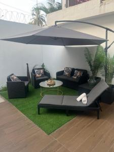 ein Wohnzimmer mit zwei Sofas und einem Regenschirm in der Unterkunft DELYA Maria in Abidjan
