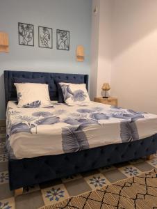 un grand lit avec une tête de lit bleue dans une chambre dans l'établissement T2 tout confort, cité, parking, à Carcassonne