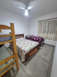 ein Schlafzimmer mit einem Bett und einem Etagenbett in der Unterkunft Apto 414- Prédio em frente da praia in Praia Grande