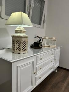 a white dresser with a lamp on top of it at Apartman FIKA in Prijepolje