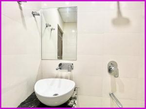 a white bathroom with a toilet and a mirror at Hotel Gunjan Palace Near Sea Beach And Jagannath Temple - Free Wifi and Parking Facilities - Best Hotel In puri in Puri