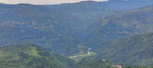 vistas a un valle de montaña con una carretera sinuosa en The River View Crescent, en Kurseong