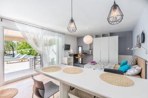 a kitchen and living room with a table and chairs at Holiday Home Vuko in Sevid