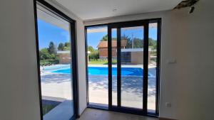 Habitación con puertas correderas de cristal con vistas a la piscina. en Daisy3, en Banja Luka