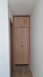 a closet with a wooden cabinet in a room at Daisy3 in Banja Luka