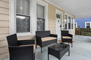 un porche con sillas y una mesa en una casa en Charming 4BR Retreat in Arlington Sleeps 12 NearDC, en Arlington