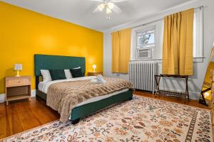 Un dormitorio con una cama y una pared amarilla. en Charming 4BR Retreat in Arlington Sleeps 12 NearDC, en Arlington 45 fotos más