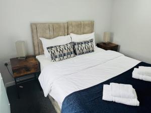 a bedroom with a large white bed with two night stands at 1 bed ground floor flat free parking in Peterborough