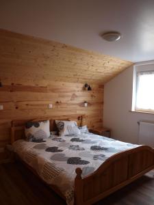 a bedroom with a bed with a wooden wall at Gîtes pour 2 à 6 personnes Manala et Vivala in Metzeral