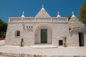 a small stone building with a green door at Trulli Moranera in Cisternino