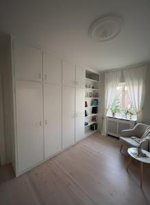 a living room with white cabinets and a table at Cosy City Apartment in Odense