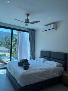 a bedroom with a bed with a ceiling fan at Villa Thai Sabai 2, Lamai in Lamai
