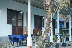 a house with a table and chairs and a palm tree at Ramya Ru Nature Resort in Galle