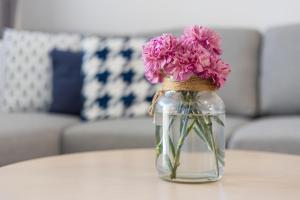 een glazen pot gevuld met roze bloemen op een tafel bij Costa Calma Rio 2 Barca Beach in Costa Calma