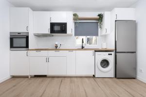 een keuken met witte kasten en een wasmachine en droger bij Costa Calma Rio 2 Barca Beach in Costa Calma +10 foto's