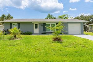 a green house with two trees in a yard at Modern 2BR with Backyard near Beach & Harbor in Port Charlotte