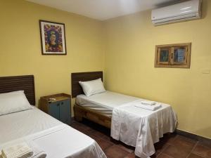 a hotel room with two beds and a window at Hotel Loro Tuerto in Santa Cruz de Barahona