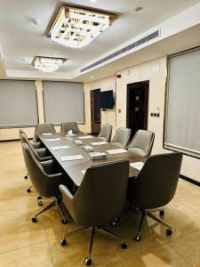 a conference room with a long table and chairs at Al Ertiqaa Hotel in Jeddah