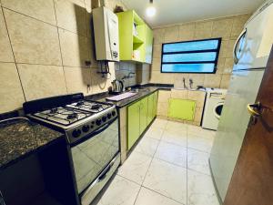 a kitchen with green cabinets and a stove top oven at Apartment in Nueva Córdoba in Cordoba