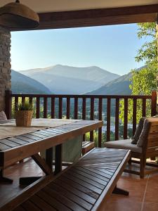 a wooden deck with a table and a view of mountains at Mirador de Punta Corona in Borrastre