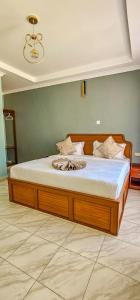 a bedroom with a large bed with white sheets at Juniper Park Resort in Nyahururu