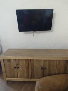 a flat screen tv on top of a wooden cabinet at Cueva la estrella in Chinchilla de Monte Aragón