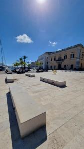 Un grupo de bancos en una plaza en Maredì Brindisi vacation home, en Brindisi