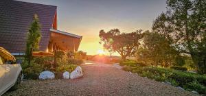 a car parked in front of a house with the sunset at Juniper Park Resort in Nyahururu