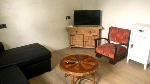 a living room with a couch and a tv and a table at Palmeras in Elche