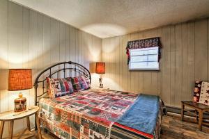 a bedroom with a bed and a table and a window at Modern Rustic Cabin - Cozy Forest Escape in Gatlinburg