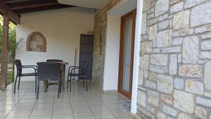 a patio with chairs and a table and a stone wall at Plaja 10 dk , Bahçeli, Huzurlu Tatil Evi in Datca