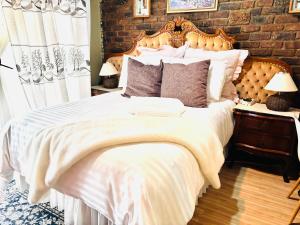 a bedroom with a large bed and a brick wall at Nalana Guest House in Thaba Nchu