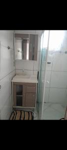 a small bathroom with a sink and a shower at Casa Bela Vista in Blumenau