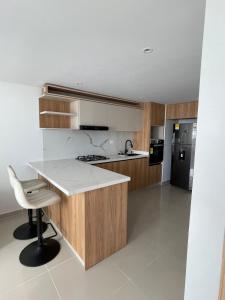 a kitchen with wooden cabinets and a white counter top at Apartamento Sur de Cali in Cali