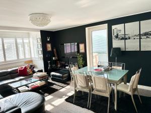a living room with a table and a couch at CENTRAL HOVE Large 2 bedroom Private residence with PARKING & BEACH HUT in Brighton & Hove