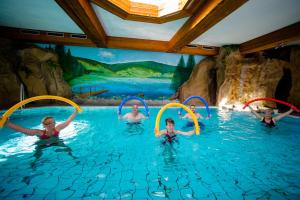 eine Gruppe Kinder, die in einem Wasserpark im Wasser spielen in der Unterkunft Holzschuhs Schwarzwaldhotel in Baiersbronn