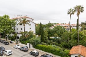 a city street with cars parked in front of a building at Luxury apartment in Monte Estoril in Estoril