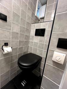 a bathroom with a toilet with a black seat at Central Guest Rooms in Amsterdam
