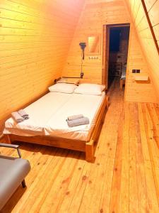 a bedroom with a bed in a wooden room at La Seasons in Hors
