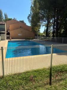 a fence around a swimming pool in front of a house at Arles Camargue in Arles