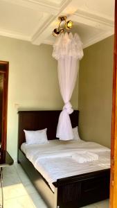 a bedroom with a bed with a curtain on it at Safari Hotel Lyantonde in Lyantonde