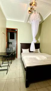 a bedroom with a bed and a desk in a room at Safari Hotel Lyantonde in Lyantonde