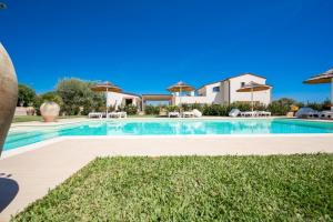 a swimming pool with chairs and umbrellas at Villa Carmiano Luxury bedrooms in Avola in the province of Syracuse with room with swimming pool in Avola