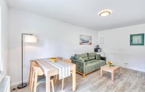 a living room with a table and a green couch at Beach Front Apartment In Altenkirchen With Wifi in Altenkirchen