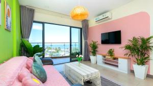 un salon avec un mur rose et vert dans l'établissement Aria Vũng Tàu - Blue Sapphire Resort Căn Hộ, Biệt Thự Nghỉ Dưỡng Cách Biển 50m, à Xã Thắng Nhứt