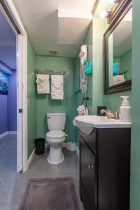 Un baño con inodoro, lavabo y espejo. en NYC Living Style, en Laurel