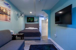Un dormitorio con una cama, un sofá y un televisor. en NYC Living Style, en Laurel