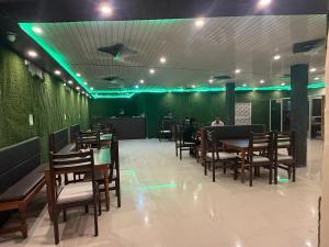 a restaurant with wooden tables and chairs and green lights at Riddhi kitchen in Silao +5 photos