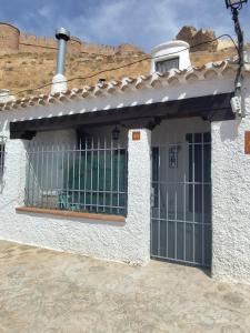 una casa blanca con una puerta delante de ella en Cueva del castillo de Chinchilla, en Chinchilla de Montearagón